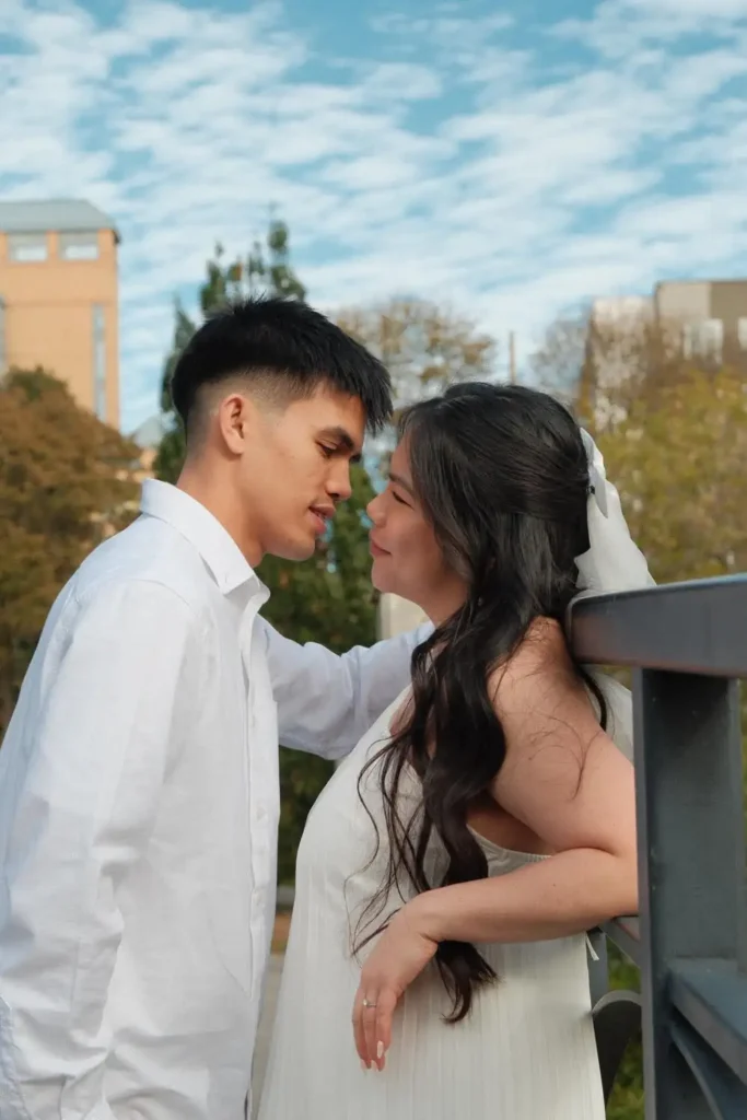 Foreheads close at a bridge railing