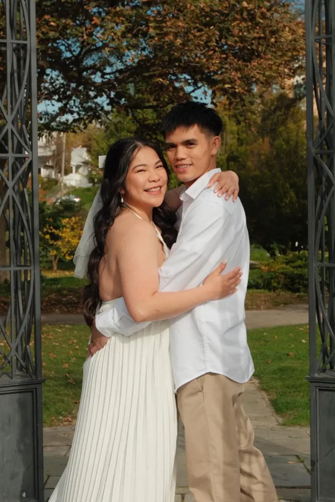 Hugging and smiling at the camera in a garden gazebo