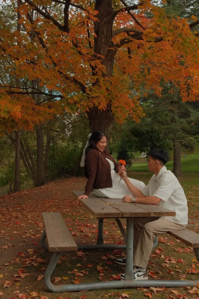 Earl offers Den an orange flower at a picnic table
