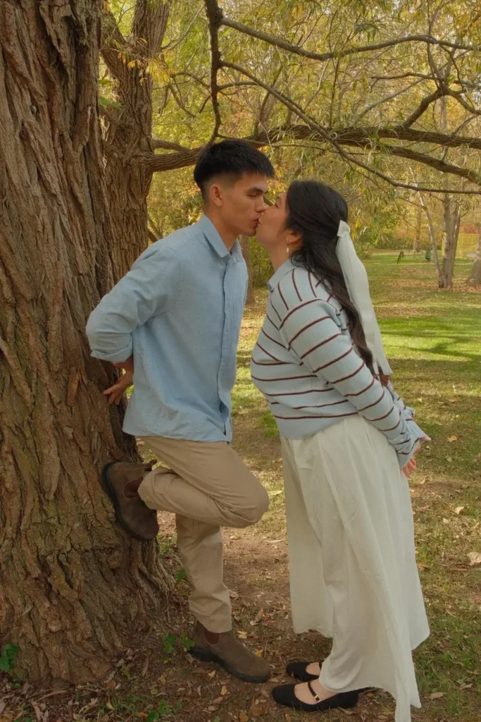 A kiss against the trunk of an old willow